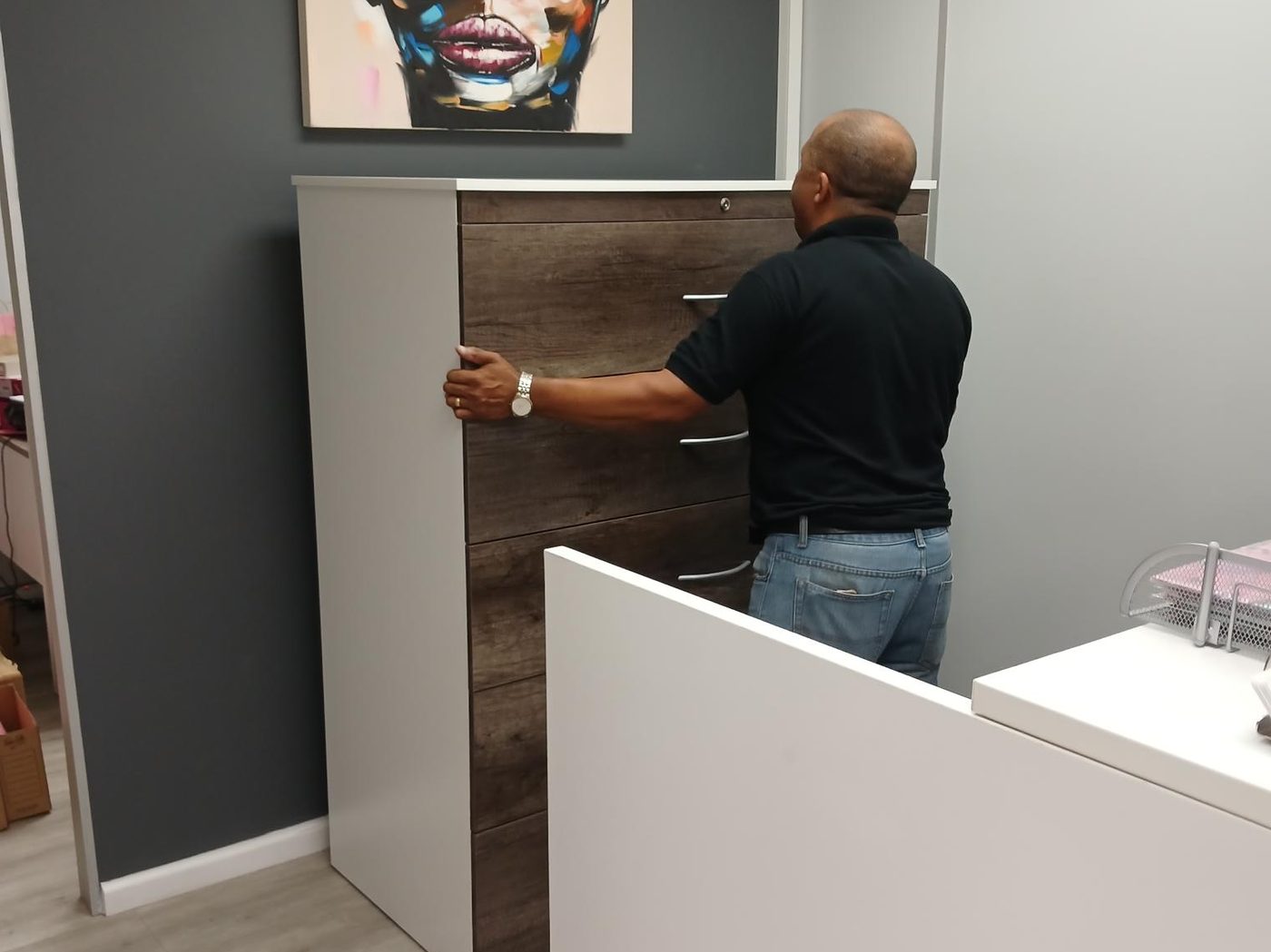 Installer fitting a cabinet at a client office