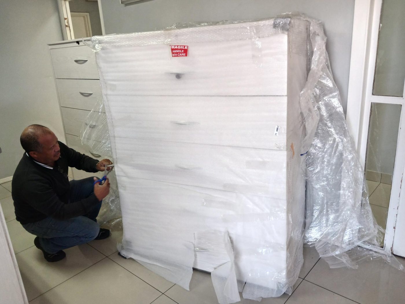Cabinet delivered and being unwrapped on site